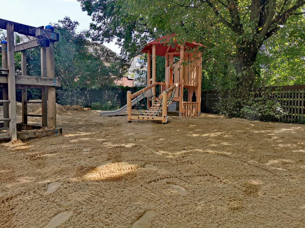 Frisch planierter Sandbereich im Garten mit Spielhaus