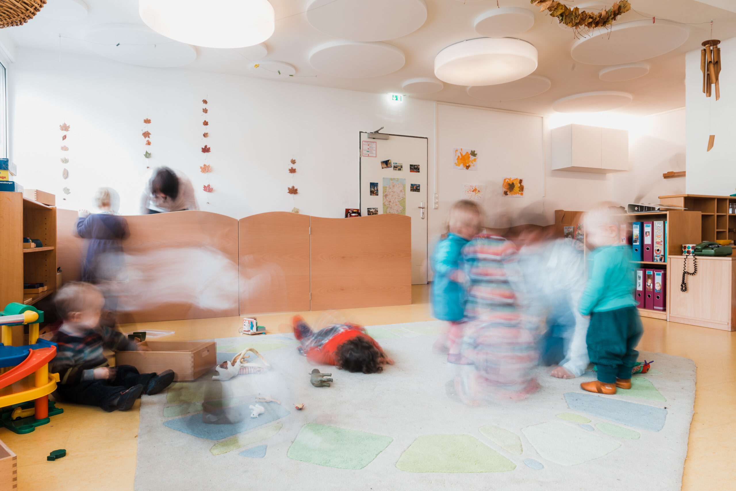 Gruppenraum der Raupen beim Spielen, die Kinder sind nur verschwommen zu sehen