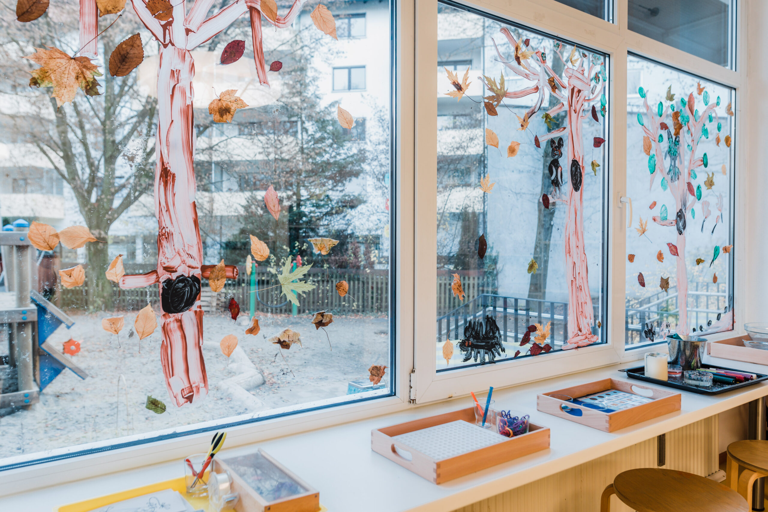 Große Fenster mit einem gebastelten Herbstbaum und Blättern