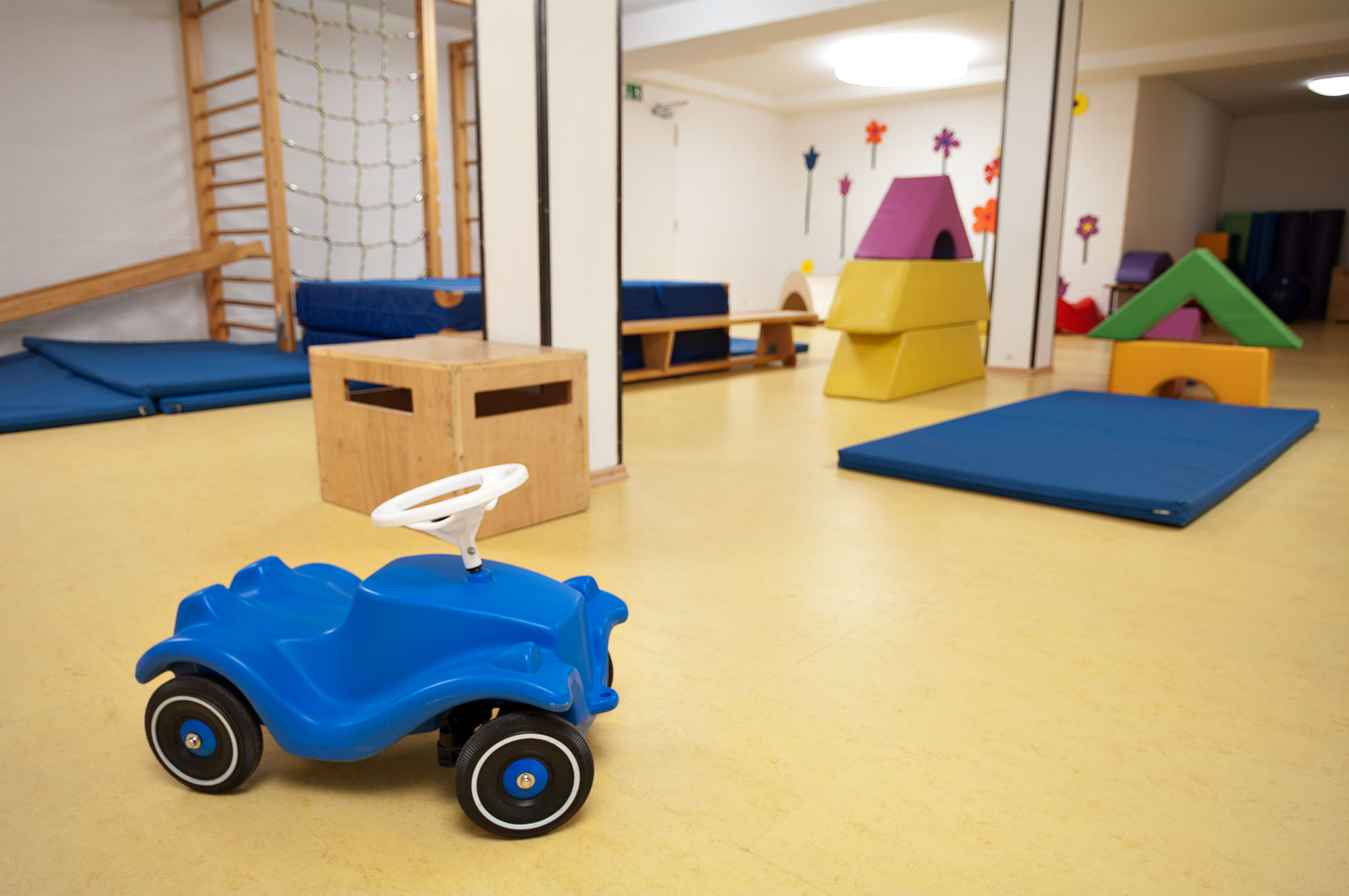 Großer Turn- und Bewegungsraum mit Sprossenwand, Matten und Bobbycar