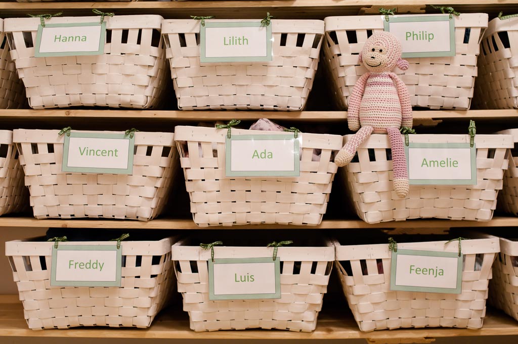 Regal mit beschrifteten Körben für die Wechselwäsche der Kinder