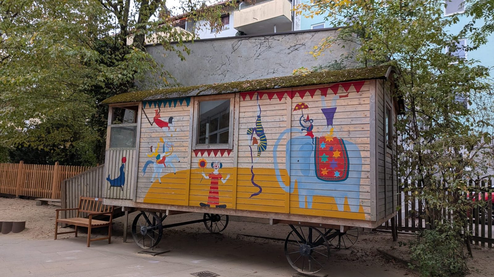 Bunt bemalter Zirkuswagen mit Elefant, Clown und Akrobaten im Garten der Bärchen